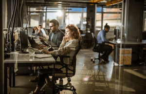 Employees working at desks in a busy open-plan office