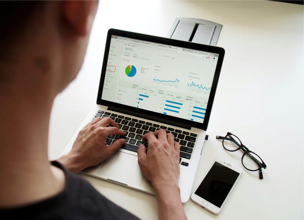 Person reviewing data and analytics charts on a laptop
