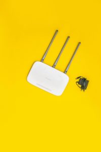 A white Wi-Fi router on a yellow background