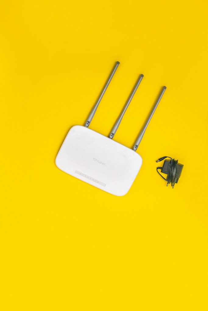 A white Wi-Fi router on a yellow background
