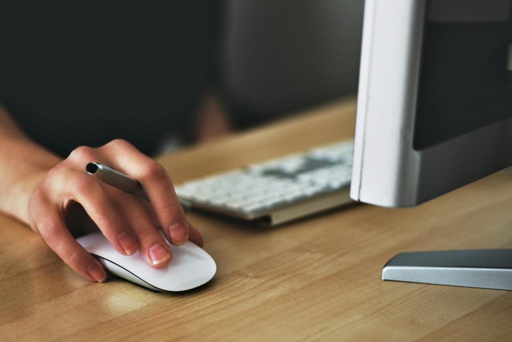 Hand using a wireless mouse at a desk
